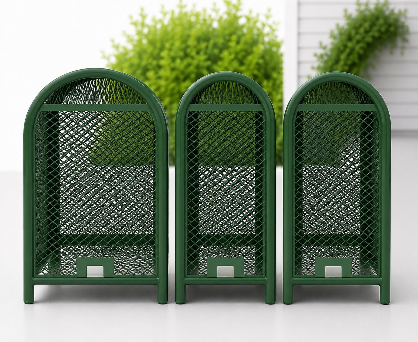 Three green metal backflow cages lined up outdoors